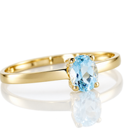 Anillo de oro amarillo 18k con topacio azul ovalado