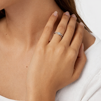 Anillo de oro blanco con diamante negaste invisible en forma de flor y aro cruzado